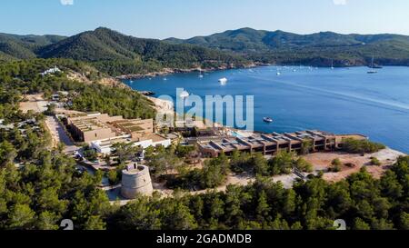 Luftaufnahme des runden Turms (Torre) von Portinatx am Nordufer der Insel Ibiza in Spanien - Pinienwälder und felsige Klippen auf der Baleareninsel Stockfoto