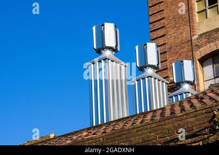 Neue Stahlschornsteine auf einem alten industriellen Umfeld, blauer Himmel. Stockfoto