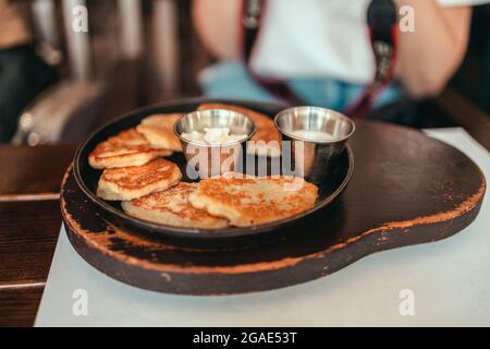 Köstliche hausgemachte vegane Kartoffelpfannkuchen auf einem Teller im Straßencafé. Traditionelles, köstliches Essen Stockfoto