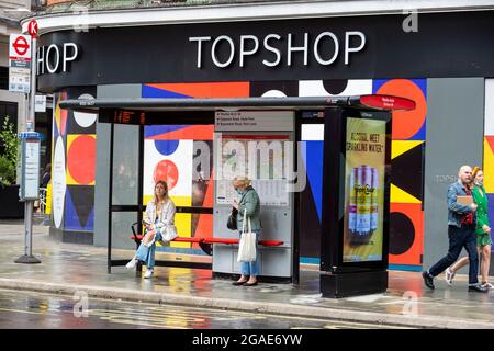 London, Großbritannien. 30. Juli 2021. Menschen vor einem leeren Topshop-Laden in der Oxford Street. Laut einem Bericht des British Retail Consortium (BRC) und des Local Data Company ist jeder siebente Laden in ganz Großbritannien leer, da Einzelhändler weiterhin unter den Auswirkungen der Covid-Pandemie auf die Besucherfrequenz leiden und Kunden zum Online-Shopping wechseln. Es gibt eine starke Kluft zwischen dem Süden Englands, einschließlich London, mit niedrigeren Leerstandsquoten im Vergleich zum Norden des Landes. Kredit: Stephen Chung / Alamy Live Nachrichten Stockfoto