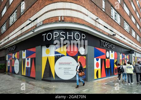 London, Großbritannien. 30. Juli 2021. Leute kommen an einem leeren Topshop-Laden in der Oxford Street vorbei. Laut einem Bericht des British Retail Consortium (BRC) und des Local Data Company ist jeder siebente Laden in ganz Großbritannien leer, da Einzelhändler weiterhin unter den Auswirkungen der Covid-Pandemie auf die Besucherfrequenz leiden und Kunden zum Online-Shopping wechseln. Es gibt eine starke Kluft zwischen dem Süden Englands, einschließlich London, mit niedrigeren Leerstandsquoten im Vergleich zum Norden des Landes. Kredit: Stephen Chung / Alamy Live Nachrichten Stockfoto