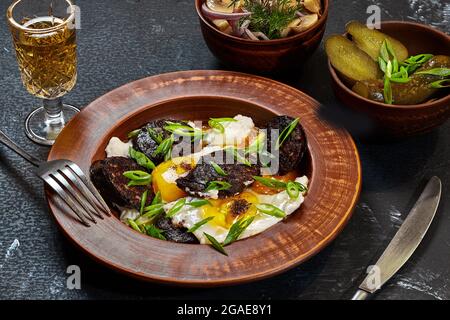 Spiegeleier mit Blutwurst, Gurken, Pilzen und Likör Stockfoto