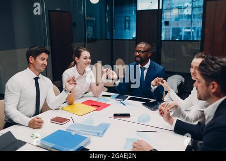 Das Team von Geschäftsleuten meditiert und hält sich nach dem Büromeeting die Hände. Business People Group Konferenz Diskussion Meditationskonzept Stockfoto