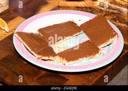 Zwei Scheiben Toast in zwei Hälften geschnitten mit Schokoladenüberzug mit Krusten auf einem rosa Teller für Kinder entfernt Stockfoto