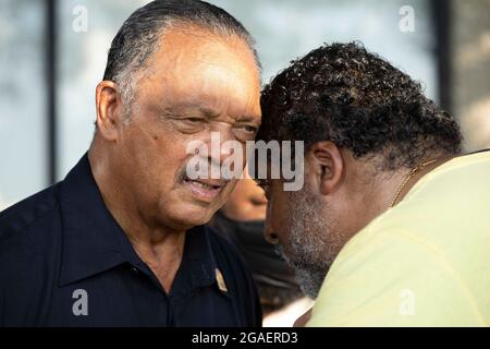 Austin, Texas, USA, 30. Juli 2021: Der Bürgerrechtler, Rev. Jesse Jackson, spricht mit Rev. William Barber II., während sie sich Wahlrechtlern auf einem marsch entlang einer Autobahn-Frontage in Richtung Texas Capitol aus Nord-Austin anschließen, am dritten Tag einer 30 Meilen langen Reise, die gegen die republikanischen Bemühungen zur Unterdrückung von Stimmen im ganzen Land protestiert In Texas. Verschiebungen von Marschern handeln in dem Bemühen, die drückende Hitze von Texas zu bekämpfen. Kredit: Bob Daemmrich/Alamy Live Nachrichten Stockfoto