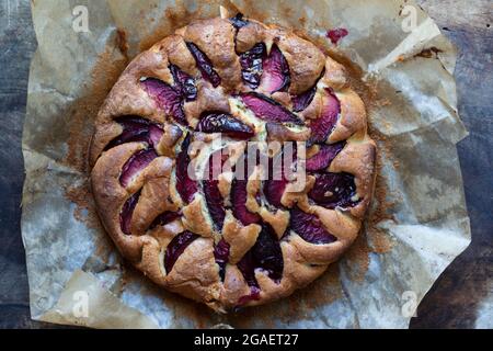 Runden Sie den frisch gebackenen Pflaumenkuchen auf dem Holzbrett Stockfoto