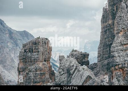 Kleine Climber Silhouette steht auf beeindruckende und malerische Cinque Torri Formation Klippe, die Dolomiten Panorama genießen. Extrem aktiv Stockfoto