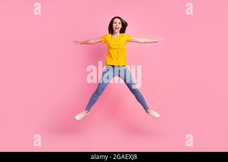 Foto von Glück liebenswert junge Frau gekleidet gelb T-Shirt springen hoch wie Stern isoliert rosa Farbe Hintergrund Stockfoto