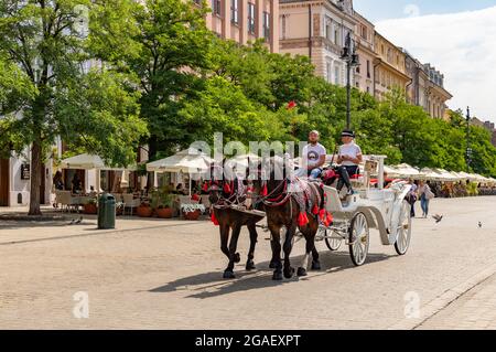 Ein Bild der berühmten Pferdekutschen auf dem Krakauer Hauptplatz. Stockfoto