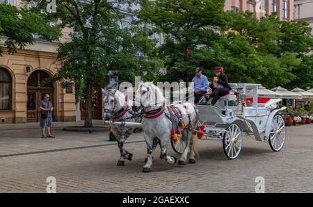 Ein Bild der berühmten Pferdekutschen auf dem Krakauer Hauptplatz. Stockfoto