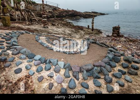 Stein- oder Steinskulpturen spiralförmig und balancierte Steinstapel am Strand, Dunbar, East Lothian, Schottland, Großbritannien Stockfoto