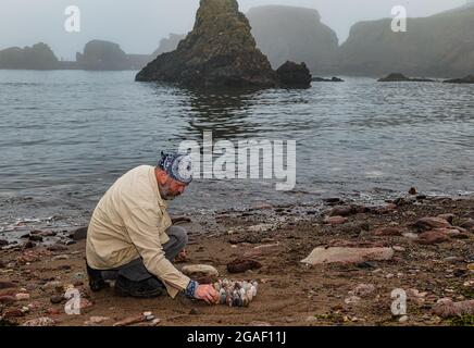 Der Landkünstler James Brunt kreiert am Strand, Dunbar, East Lothian, Schottland, Großbritannien, eine Stein- oder Felsskulptur Stockfoto
