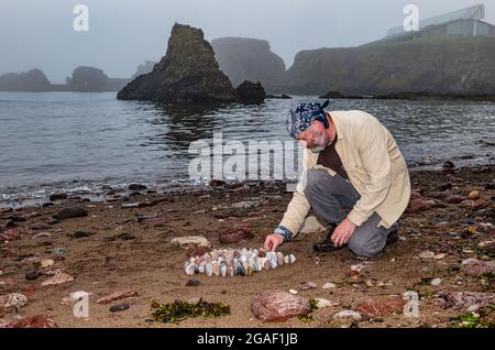 Der Landkünstler James Brunt kreiert am Strand, Dunbar, East Lothian, Schottland, Großbritannien, eine Stein- oder Felsskulptur Stockfoto