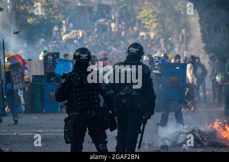 Zwei kolumbianische Bereitschaftspolizisten stehen beim Zusammenprall der Demonstranten, als die Demonstrationen in späten Nachtszenen zwischen der kolumbianischen Bereitschaftspolizei (ESMAD) und den Demonstranten endeten, da Kolumbien 3 Monate lang Anti-Government-Proteste gegen die kolumbianische Regierung Ivan Duque feiert, Und eine neue Steuerreform inmitten von Unruhen und Gewalt, die seit Beginn der Proteste mindestens 83 Tote hinterlassen haben. Am 28. Juli 2021 in Medellin - Antioquia, Kolumbien. Stockfoto