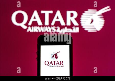 In dieser Abbildung sehen Sie ein Qatar Airways-Logo auf einem Smartphone mit einem Qatar Airways-Logo im Hintergrund. Stockfoto