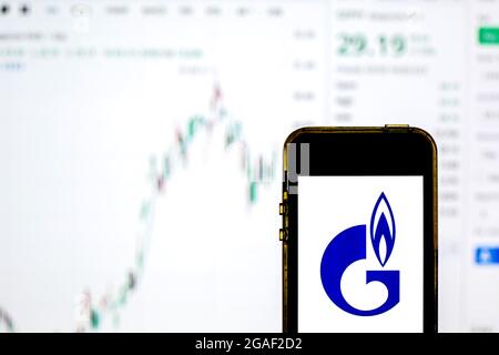In dieser Abbildung ist ein Gazprom-Logo auf einem Smartphone mit den Börseninformationen von Gazprom im Hintergrund zu sehen. Stockfoto