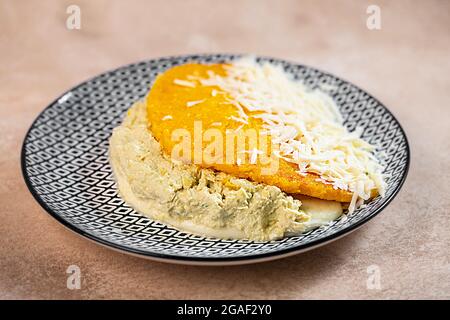 Gefüllte Arepa auf einem Teller aus Maismehl, traditionelle Küche von Kolumbien und Venezuela zubereitet Stockfoto