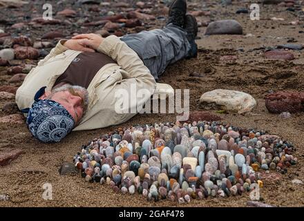 Der Landkünstler James Brunt kreiert am Strand, Dunbar, East Lothian, Schottland, Großbritannien, eine Stein- oder Felsskulptur Stockfoto