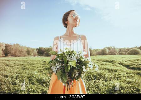 Hübsche weibliche Hände mit Blumenstrauß. Portrait von Mädchen mit Blumen. Sommerhintergrund Stockfoto