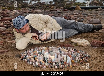 Der Landkünstler James Brunt kreiert am Strand, Dunbar, East Lothian, Schottland, Großbritannien, eine Stein- oder Felsskulptur Stockfoto