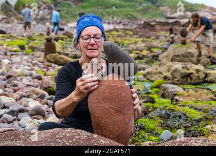 Caroline Walker, Steinstapler, balanciert Steine bei der European Stone Stacking Championship am Strand, Dunbar, East Lothian, Schottland, Großbritannien Stockfoto