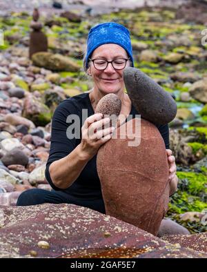 Caroline Walker, Steinstapler, balanciert Steine bei der European Stone Stacking Championship am Strand, Dunbar, East Lothian, Schottland, Großbritannien Stockfoto