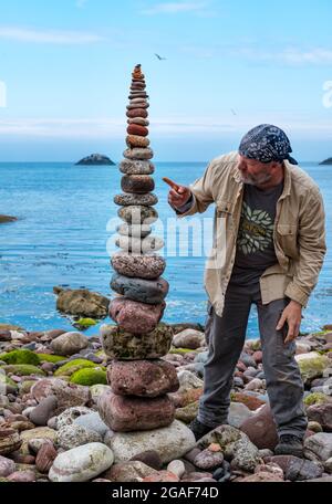 James Brunt, Landkünstler, stapelt Steine in einem Turm bei der European Stone Stacking Championship on the Beach, Dunbar, East Lothian, Schottland, Großbritannien Stockfoto