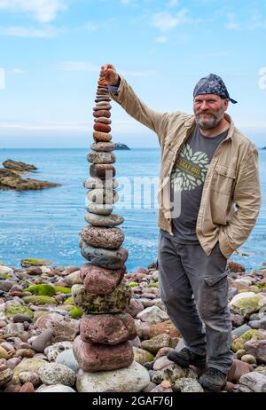 James Brunt, Landkünstler, stapelt Steine in einem Turm bei der European Stone Stacking Championship on the Beach, Dunbar, East Lothian, Schottland, Großbritannien Stockfoto