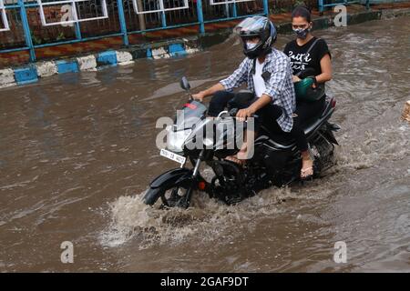 Kalkutta, Indien. Juli 2021. Pendler waten nach dem Regen in Kalkutta durch eine wasserstrasse Flutwasser. (Foto von Dipa Chakraborty/Pacific Press) Quelle: Pacific Press Media Production Corp./Alamy Live News Stockfoto