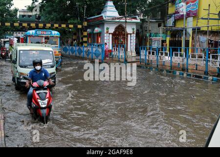 Kalkutta, Indien. Juli 2021. Pendler waten nach dem Regen in Kalkutta durch eine wasserstrasse Flutwasser. (Foto von Dipa Chakraborty/Pacific Press) Quelle: Pacific Press Media Production Corp./Alamy Live News Stockfoto