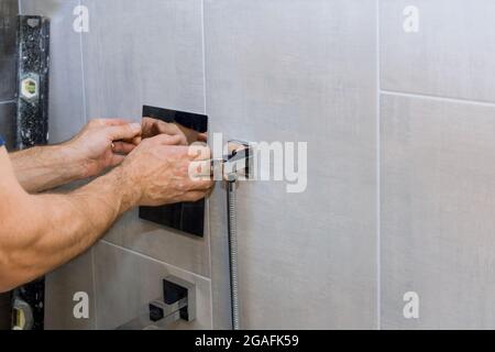 Klempner Hände zur Festsetzung Mischbatterie Dusche auf modernen Leitungswasser. Stockfoto