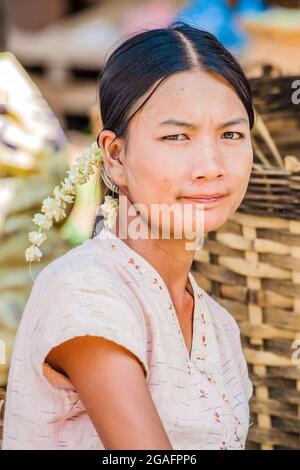 Hübsche junge Burma mit Haargirlande und traditioneller Bluse sitzt posiert für Foto, Mine Thauk, Inle Lake, Myanmar Stockfoto