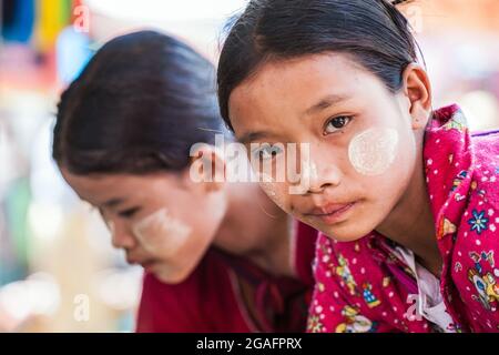 Hübsches junges burmesisches Mädchen mit Thanaka-Gesichtspuder, das die Kamera, Mine Thauk, Inle Lake, Myanmar anschaut Stockfoto