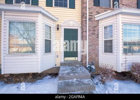 Vordertürfassade eines Stadthauses mit Erkerfenstern und schneebedecktem Hof Stockfoto