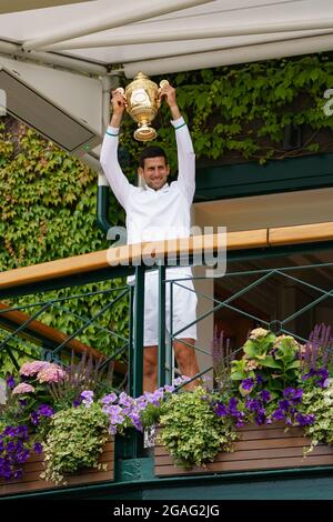 Novak Djokovic aus Serbien hält vom Balkon des Center Court aus die Männer-Einzel-Trophäe für Fans ab Stockfoto
