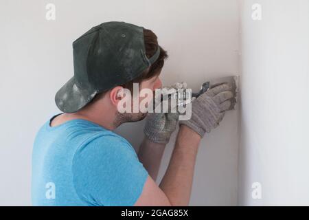 Älterer Mann mit Kitt Messer Verputzen Reparatur Wand Stockfoto