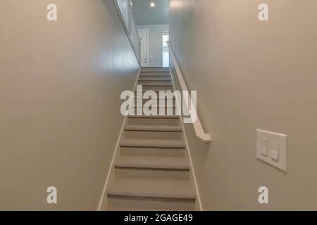 Teppichboden Treppe in der Mitte einer Wand mit Blick auf eine Tür und Fenster im Obergeschoss Stockfoto