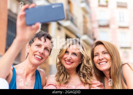 Drei reife Freundinnen, die ein Selfie in der Stadt machen Stockfoto