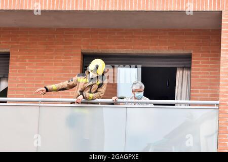 Ein Feuerwehrmann aus Katalonien, der mit einem Mieter auf der Terrasse eines Hauses bei einer Inspektion auf ein mögliches Gasleck in Vendrell gesehen wurde. Ein starker Gasgeruch alarmierte die Bewohner der San Jordi Street in Vendrell, wo drei Teams von Catalonia Firefighters und mehrere örtliche Polizeipatrouillen den Zugang zum betroffenen Gebiet verschließten. Feuerwehrleute begannen mit Hilfe von Technikern des Gasunternehmens mit den Gasmessungen, da der Geruch aus dem unterirdischen Kanalnetz kam und das Vorhandensein von Dämpfen oder Konzentrationen von Propan, Butan oder Erdgas ausgeschlossen wurde, so dass ein Gasleck ausgeschlossen wurde und das p Stockfoto