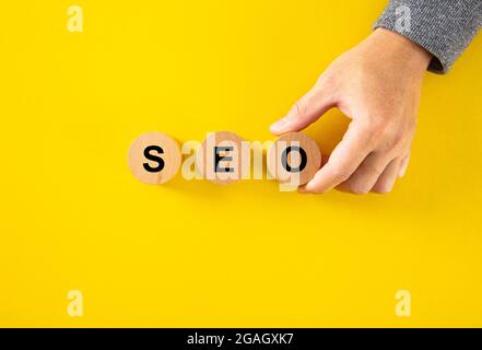 SEO (Search Engine Optimization) Text Holzwürfelblöcke auf gelbem Hintergrund. Idee, Strategie, Marketing, Keyword und Content-Konzept Stockfoto