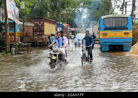 Kalkutta, Indien. Juli 2021. Menschen, die in den Folgejahren durch eine Wasserstraße fahren. Kolkata erhielt den schwersten Regenguss der Saison, der durch ein Niederdrucksystem über Bangladesch und Westbengalen verursacht wurde. (Foto: Avijit Ghosh/SOPA Images/Sipa USA) Quelle: SIPA USA/Alamy Live News Stockfoto