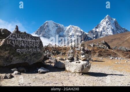 Rock mit geschnitztem tibetischem Mantra „sechs Silben Hellsehen“ und steinmandeln, Thukla Pass, Everest Base Camp Trek, Nepal Stockfoto