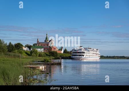 Altes Ladoga, Russland - 25. Juli 2021: Nikolski-Kloster am Ufer des Flusses Volkhov mit dem Schiff "Fjodor Dostojewski", das an der Anlegestelle angedockt ist. Stockfoto