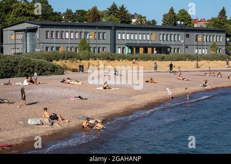 Die Menschen genießen den warmen Sommerabend am Strand von Eiran Ranta in Helsinki, Finnland Stockfoto