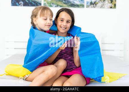 Bildung, Schule, Kunst und Glück Konzept - kleine Kinder mit der Flagge der ukraine Stockfoto