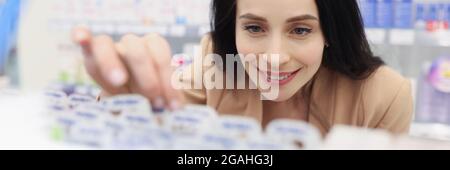 Frau im Kosmetikgeschäft nimmt Hautpflegeprodukte ab Stockfoto