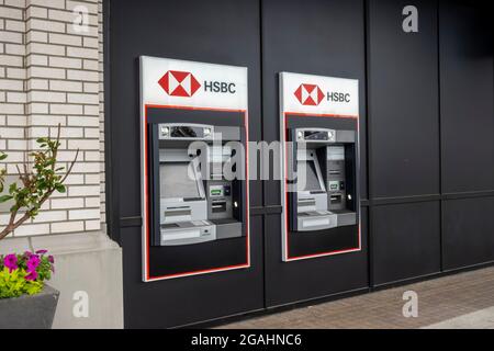 Kirkland, WA USA - ca. Juli 2021: Abgewinkelte Ansicht eines HSBC-Geldautomaten an der Seite eines Backsteingebäudes in Totem Lake Stockfoto