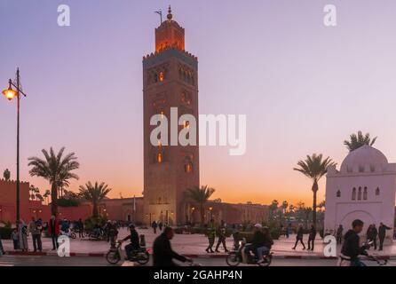 MARRAKESCH, MAROKKO - 26. DEZEMBER: Geschäftiges Straßenleben vor der Koutubia-Moschee in Marakesh - einem der beliebtesten Tourismusorte Marokkos. Stockfoto