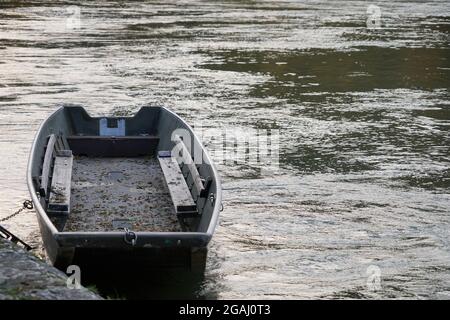 Ruderboot oder Flussufer in einer starken Strömung festgemacht. Auf der rechten Seite des Fotos ist Platz zum Kopieren verfügbar. Stockfoto