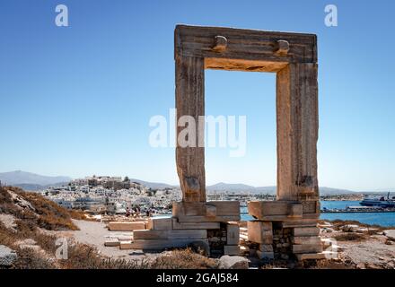 Portara (das Tor zum antiken Tempel des Apollo) und Chora (die Altstadt) auf dem Grund. Naxos ist eine griechische Insel in der Ägäis. Stockfoto